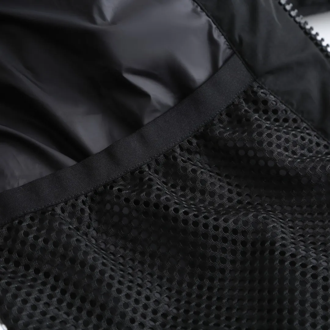 P980 Canada Goose hooded down jacket Fabric selection: Weaved with 400T high-count yarn. After special water-repellent treatment, the surface forms a lotus leaf effect - raindrops will slide down in beads, and snow particles will fall off when touched. The tear resistance reaches 200N (approximately 20kg load-bearing), the light gray matte texture breaks the stereotype of "outdoor clothing = hardcore", and the soft luster presents a high-end matte effect under urban neon lights, seamlessly switching scenes from ski resorts to CBD office buildings.  Process 1: Use polyester woven ribbons as the base, and use high-precision computer embroidery to decorate the brand letters on the ribbons. The edges of the pattern are clear, the stitches are fine and even, and multiple layers of embroidery threads are stacked to enhance the three-dimensional effect.  Process 2: Precision thread reinforcement to prevent velvet drilling and ensure that the fluffy and resilient elasticity lasts as new.  Details: The embedded cuffs are three-dimensionally woven to form a "wavy" elastic structure, forming natural folds when fitting the wrist, increasing the contact area with the skin, thus improving the windproof effect. At the same time, micro-velvet treatment is added to the inside of the cuffs, which feels like a second layer of skin and avoids friction on the skin from metal zippers or hard fabrics.  90 national standard high-quality white duck down: selected high-loft down, weighing 240g, light and warm, with excellent temperature locking performance and good resilience.  Accessories: 1:1 customized armband, 1:1 customized zipper pendant, 1:1 customized elastic buckle, etc. SIZE: S M L XL